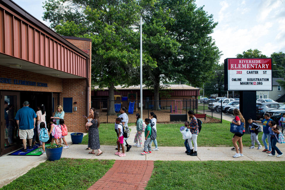 Parents walk their children to their classrooms during the first day back at Riverside Elementary school in Columbia, Tenn. on Monday, Aug. 7, 2023.