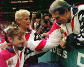 FILE - In this July 23, 1996, file photo, Bela Karolyi, right, congratulates Dominique Moceanu, left, after the United States captured the gold medal in the women's team gymnastics competition at the Centennial Summer Olympic Games in Atlanta. United States team coach Martha Karolyi, center, looks on.(AP Photo/Amy Sancetta, File)