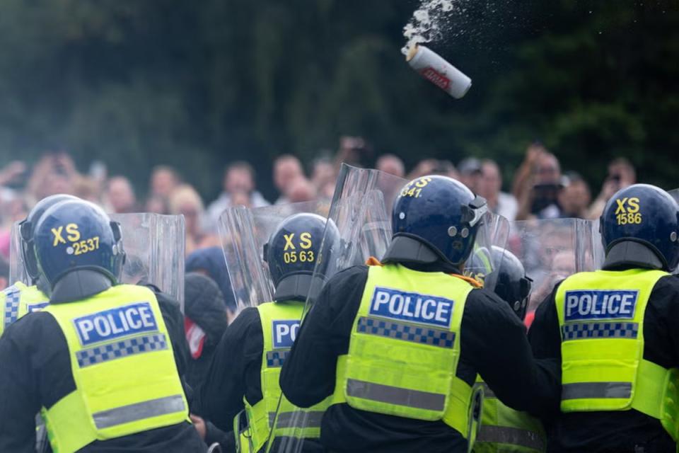 Riot police officers push back anti-migration protesters (Getty)