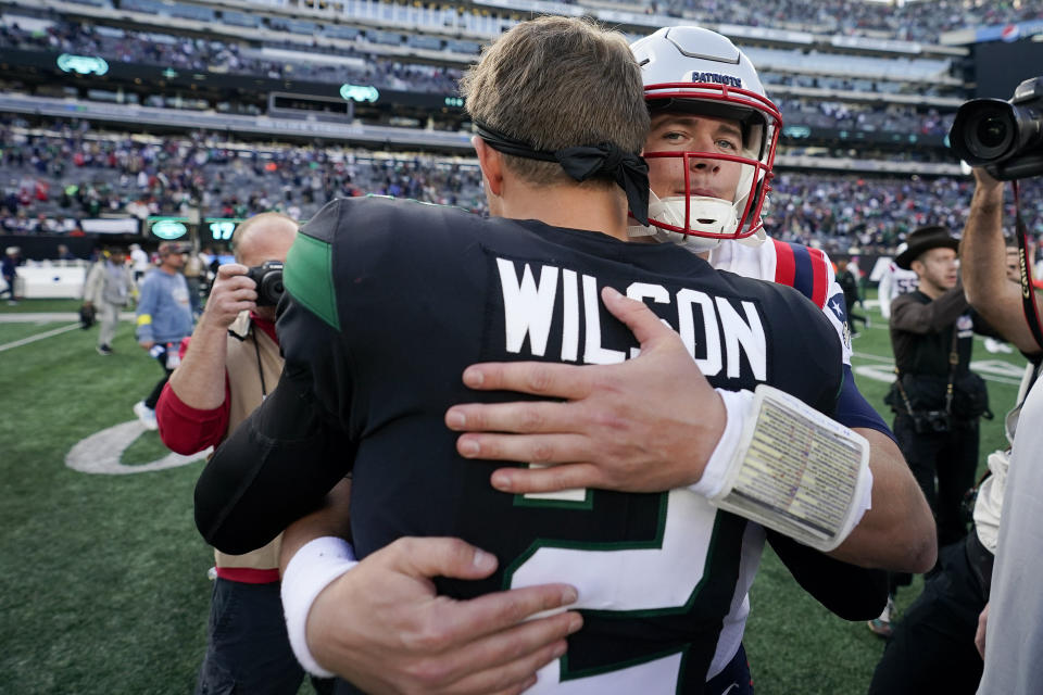 New England Patriots quarterback Mac Jones, right, greets New York Jets quarterback Zach Wilson (2) after the Patriots beat the Jets 22-17 in an NFL football game, Sunday, Oct. 30, 2022, in New York. (AP Photo/John Minchillo)