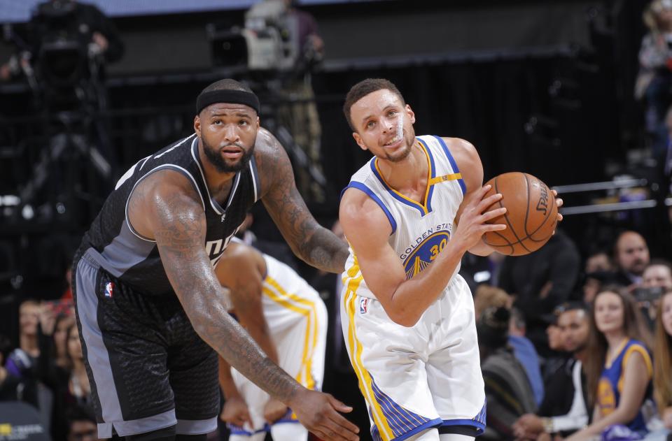 DeMarcus Cousins and Stephen Curry gaze off into the middle distance, thinking about how much money they're going to make to stay put. (Getty Images)