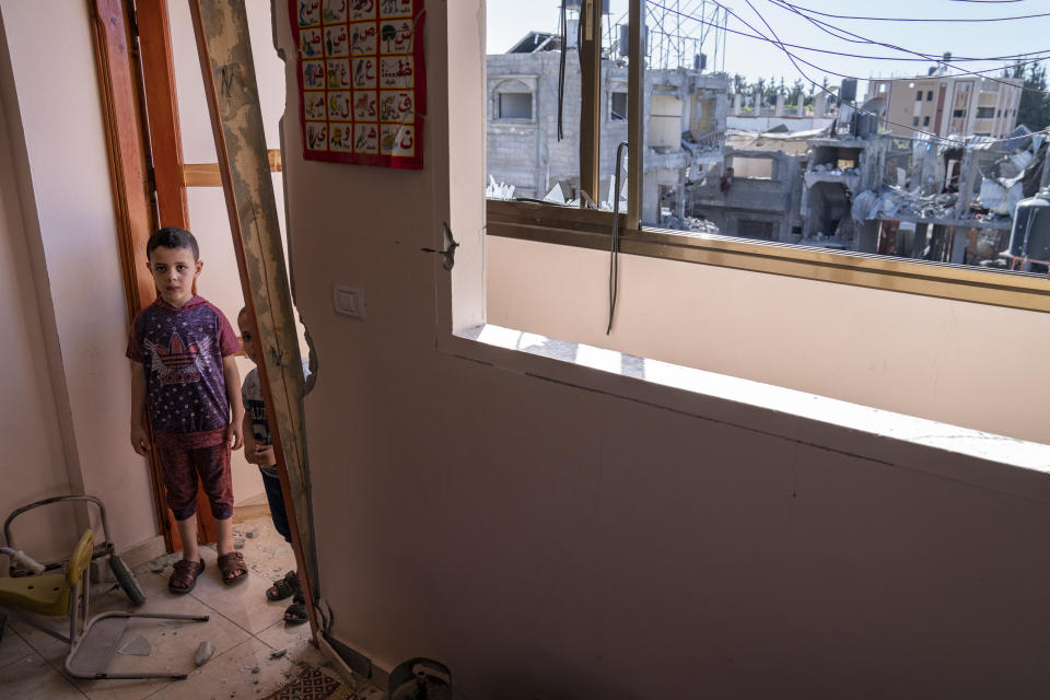 Awny Abed, 6, left, and his brother Salem, 5, stand for a portrait in their bedroom that was damaged when an airstrike destroyed the neighboring building prior to a cease-fire that halted an 11-day war between Gaza's Hamas rulers and Israel, Thursday, May 27, 2021, in Maghazi, Gaza Strip. (AP Photo/John Minchillo)