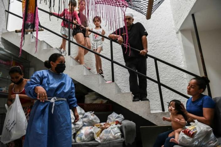 Activist Maria Isabel Diaz gives out groceries to tenants in the low-cost hotel she manages, where sex workers live and work in Medellin, Colombia (AFP Photo/Joaquin SARMIENTO)