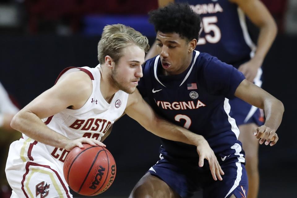 Boston College's Rich Kelly, left, drives past Virginia's Reece Beekman, right, during the first half of an NCAA college basketball game, Saturday, Jan. 9, 2021, in Boston. (AP Photo/Michael Dwyer)