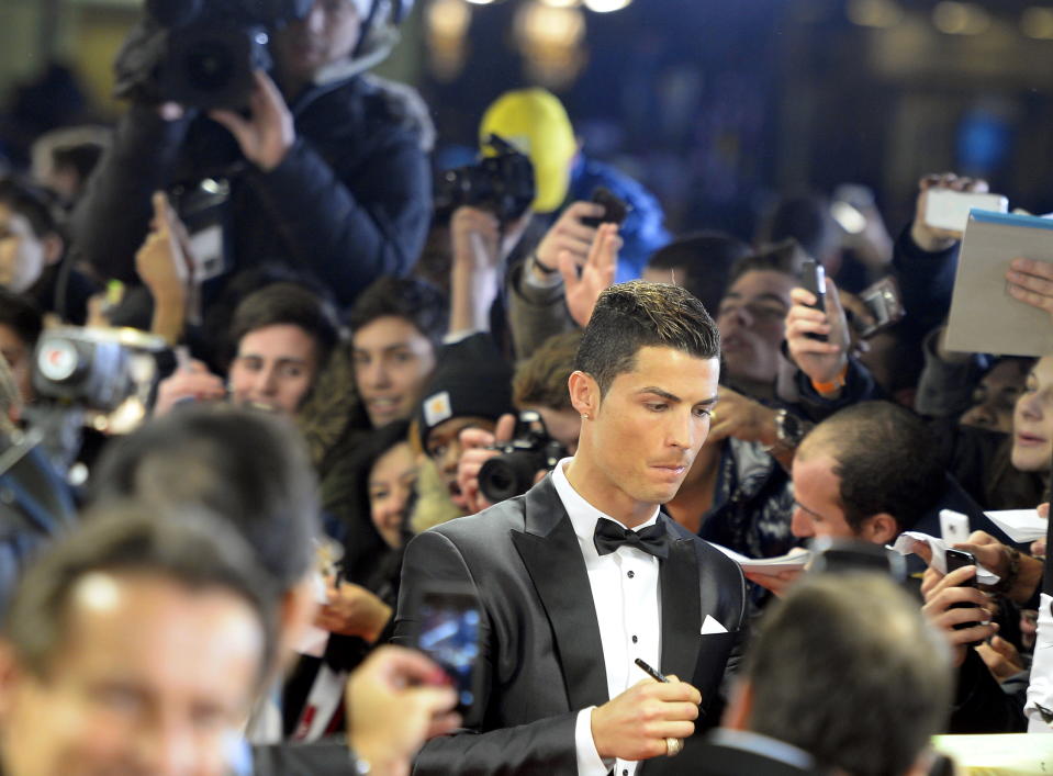 Soccer player Cristiano Ronaldo of Portugal signs autographs on the red carpet prior to the FIFA Ballon d'Or 2013 gala held at the Kongresshaus in Zurich, Switzerland, Monday, Jan. 13, 2014. (AP Photo/Keystone,Walter Bieri)