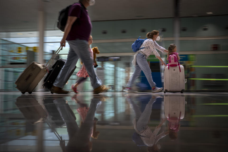 Tourists arrive at Barcelona airport, Spain, Monday, June 7, 2021. Spain is trying to ramp up its tourism industry by welcoming from Monday vaccinated visitors from most countries, as well as all Europeans who prove that they are not infected with the coronavirus. (AP Photo/Emilio Morenatti)