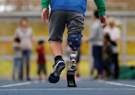 Haruta Saito tries out a prosthetic "blade" during an opening ceremony of a special "library" that lets people borrow and try out prosthetic "blades" for runners, in Tokyo, Japan, October 15, 2017. Picture taken October 15, 2017. REUTERS/Kim Kyung-Hoon