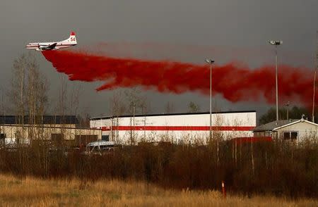 A plane flies low to dump fire retardant on wildfires near Fort McMurray, Alberta, Canada, May 6, 2016. REUTERS/Mark Blinch