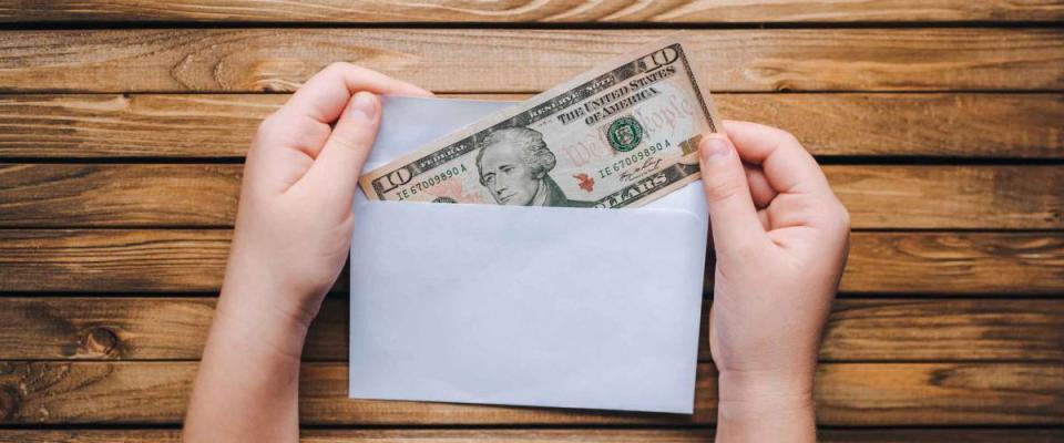 Dollar in an envelope in children's hands