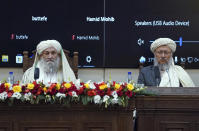 Taliban Prime Minister Mohammad Hasan Akhund, left, speaks during an economic conference at the former Presidential Palace in Kabul, Afghanistan, Wednesday, Jan. 19, 2022. Afghanistan's Taliban rulers are holding their first economic conference, five months since taking over the country that is now teetering on the verge of a humanitarian catastrophe and economic collapse. The U.N. head of mission for Afghanistan said at the gathering on Wednesday that surprising $1 billion in exports. (Taliban Prime Minister Media Office via AP)