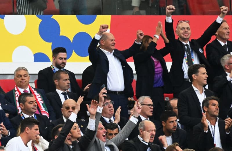 German Chancellor Olaf Scholz (C) and DFB President Bernd Neuendorf (R) celebrate their side's second goal next to Hungarian Prime Minister Viktor Orban (L) and UEFA President Aleksander Ceferin (2nd L) during the UEFA Euro 2024 group A soccer match between Germany and Hungary at Stuttgart Arena. Marijan Murat/dpa