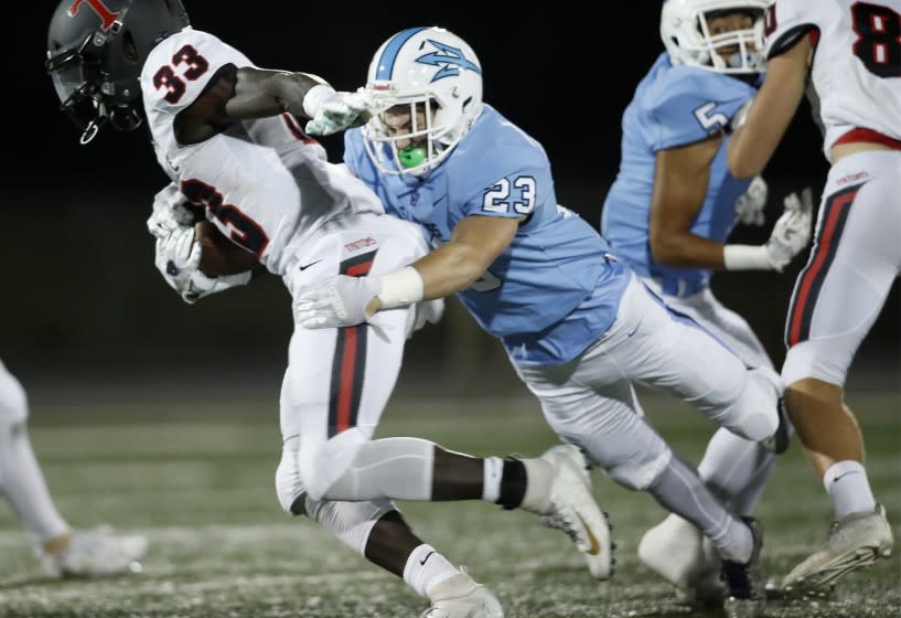 Corona del Mar High defensive back Zack Green (23) forces a fumble against San Clemente's James Bohls during the first half in a nonleague game at Newport Harbor High on Thursday. Green recovered the fumble for the Sea Kings.