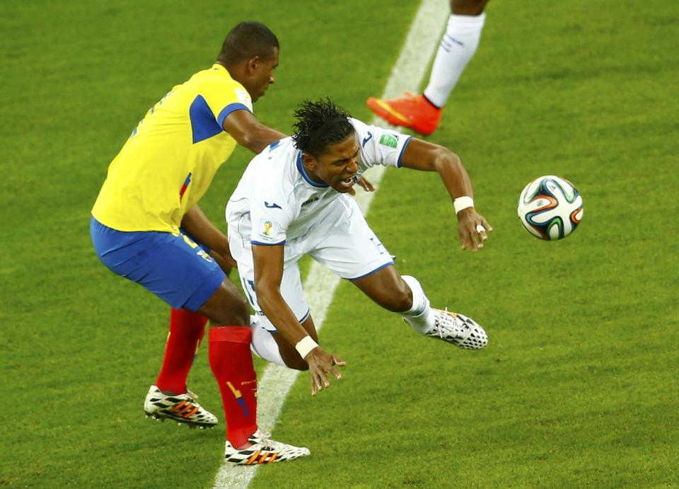 Ecuador's Jorge Guagua fights for the ball with Carlo Costly of Honduras (R) during their 2014 World Cup Group E soccer match at the Baixada arena in Curitiba June 20, 2014. REUTERS/Amr Abdallah Dalsh (BRAZIL - Tags: SOCCER SPORT WORLD CUP)