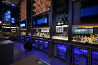 A worker checks the stock of a club-level bar inside Climate Pledge Arena, Wednesday, Oct. 20, 2021, during a media tour ahead of the NHL hockey Seattle Kraken's home opener Saturday against the Vancouver Canucks in Seattle. The historic angled roof of the former KeyArena was preserved, but everything else inside the venue, which will also host concerts and be the home of the WNBA Seattle Storm basketball team, is brand new. (AP Photo/Ted S. Warren)