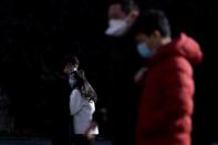 A couple wearing masks hug at a main shopping area, in downtown Shanghai