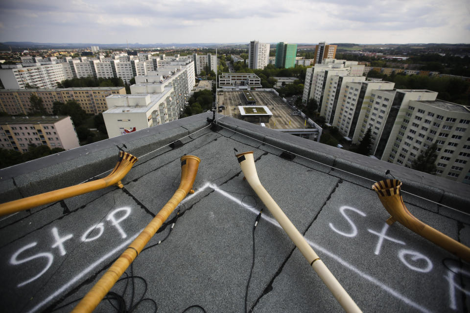 Four alphorns lie on the rooftop of an residence building during the sound check for the 'Himmel ueber Prohils', Sky over Prohlis, concert event in Dresden, Germany, Saturday, Sept. 12, 2020. About 33 musicians of the Dresden Sinfoniker perform a concert on the rooftops of the Dresden neighbourhood Prohlis. The word 'Stop' marking the ares not allowed to step in for persons. (AP Photo/Markus Schreiber)