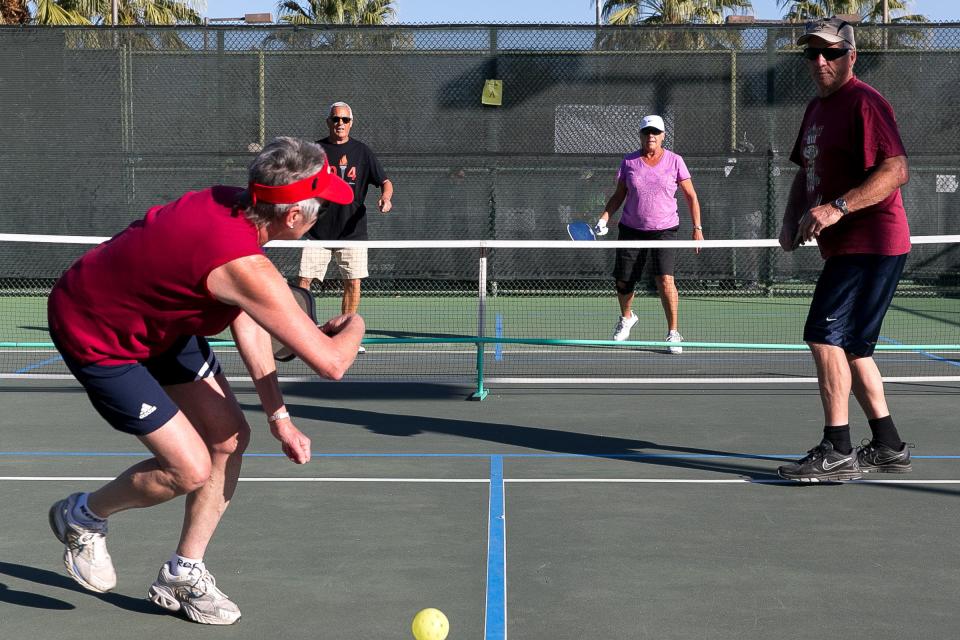 Judy Van Aert, left, is unable to return the ball during a mixed doubles pickleball game for ages 65-69 at the 14th annual Palm Desert Senior Games and International Sports Festival held at Palm Desert Civic Center Park.