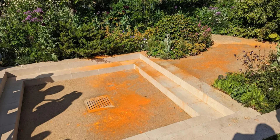 just stop oil target chelsea flower show garden with orange paint