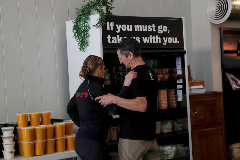 FILE PHOTO: Amy and Chris Hillyard, owners of Farley’s East cafe that closed due to the financial crisis caused by the coronavirus disease (COVID-19), embrace at the cafe in Oakland, California