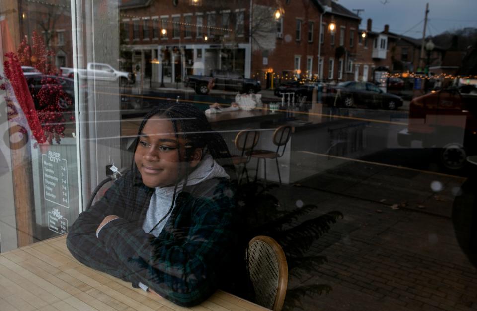 Khayta Diongue, of Khayta Photograpy, sits inside of Paper City Coffee on November 20, 2023, in Chillicothe, Ohio.