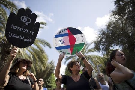 Left-wing Israeli protesters hold placards during a demonstration against the recent Palestinian-Israeli violence in Tel Aviv, Israel October 9, 2015. REUTERS/Amir Cohen