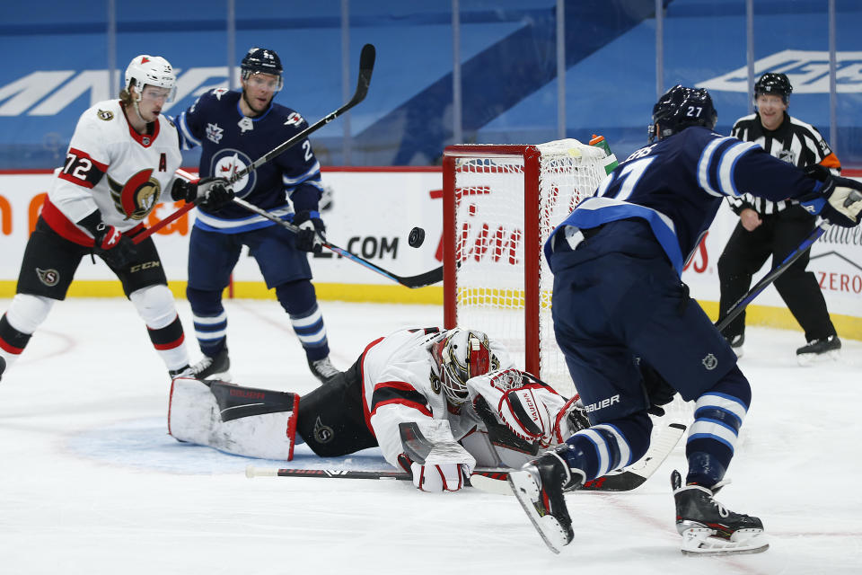 Ottawa Senators goaltender Marcus Hogberg (1) makes a save on a shot by Winnipeg Jets' Nikolaj Ehlers (27) during the second period of an NHL hockey game Saturday, Jan. 23, 2021, in Winnipeg, Manitoba. (John Woods/The Canadian Press via AP)