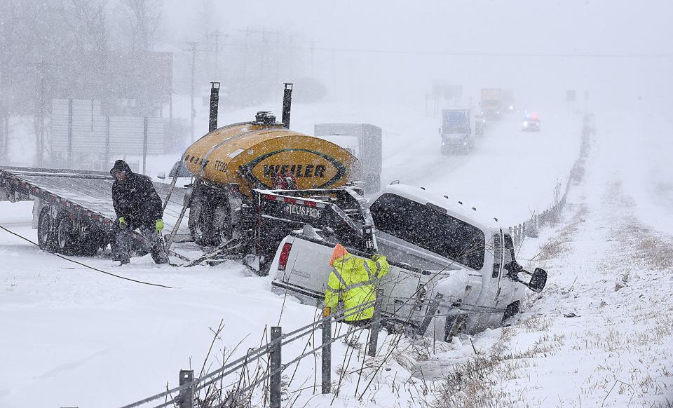 ATR Towing and Recovery workers remove a pickup truck that slid into the median on Interstate 70 east of the Lake of the Woods exit on Wednesday.