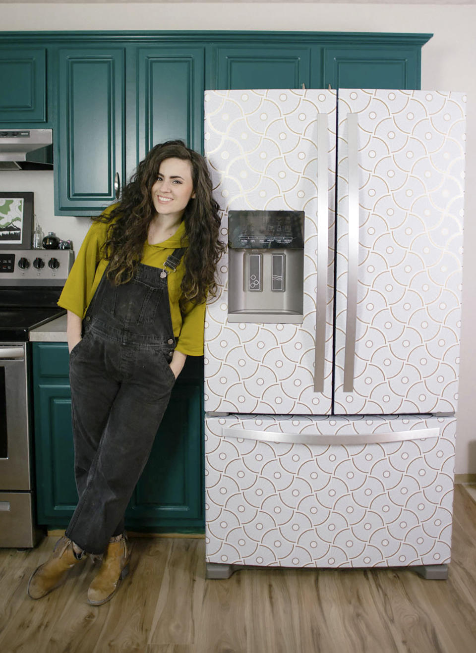 Designer Liz Morrow stands next to her refrigerator covered with a stylish patterned Tempaper removable paper at her home in Tacoma, Wash. (Liz Morrow via AP)