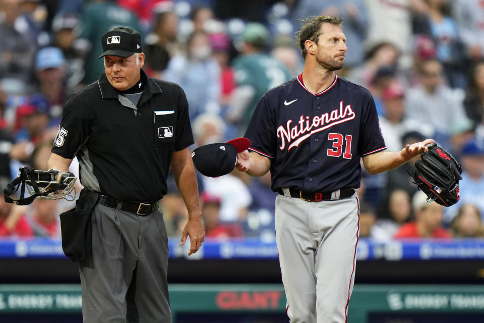 Washington Nationals pitcher Max Scherzer, right, waits to be checked for foreign substances near home plate umpire Tim Timmons after the first inning of a baseball game against the Philadelphia Phillies, Tuesday, June 22, 2021, in Philadelphia. (AP Photo/Matt Slocum)