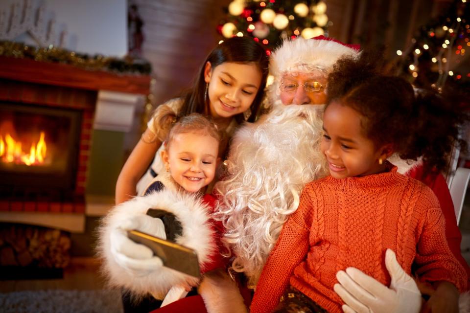 Santa Claus sharing smart phone with children