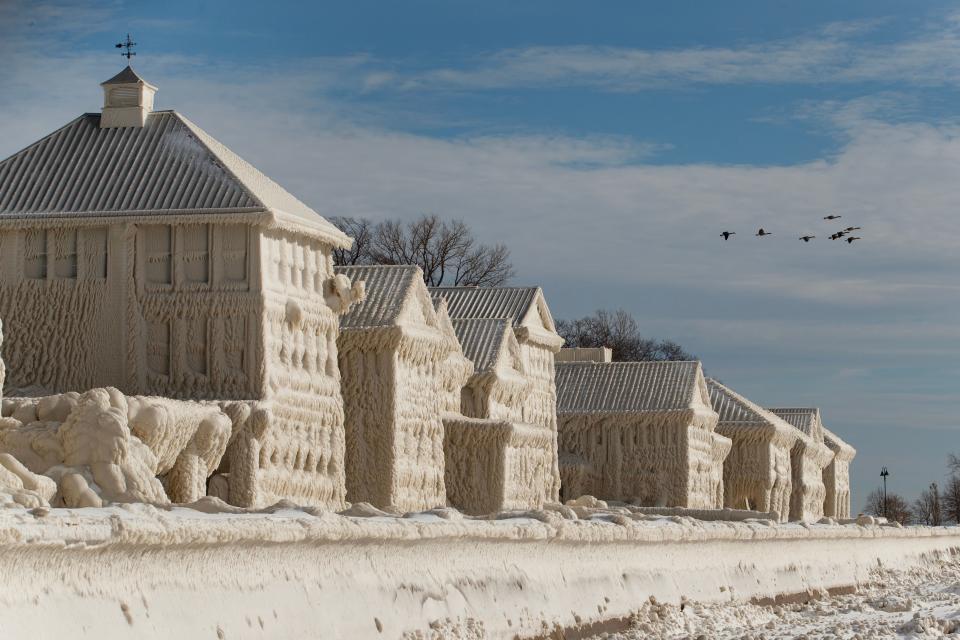 TOPSHOT - Geese fly over frozen homes in the waterfront community of Crystal Beach in Fort Erie, Ontario, Canada, on December 28, 2022, following a massive snow storm that knocked out power in the area to thousands of residents. (Photo by Cole Burston / AFP) (Photo by COLE BURSTON/AFP via Getty Images)