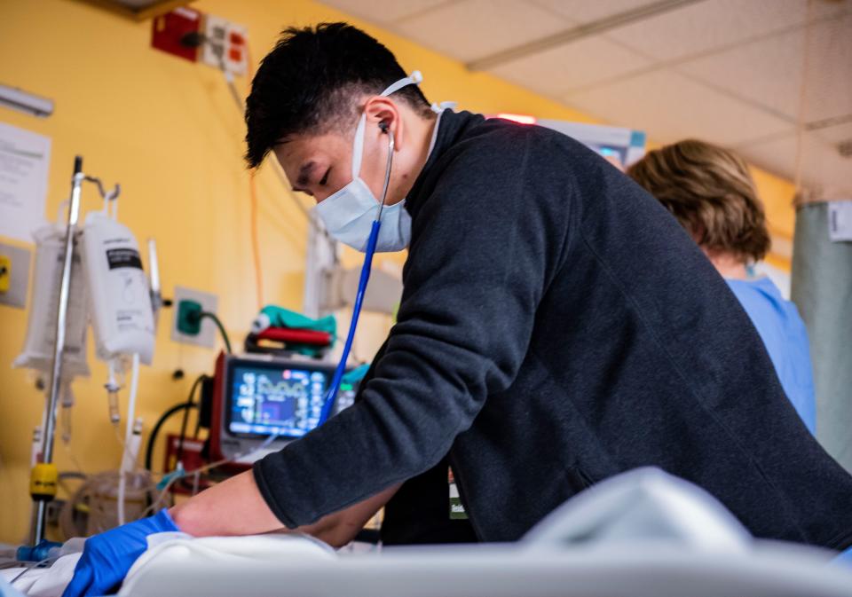 Staff care for a new arrival to the University of Vermont Medical Center Intensive Care Unit (ICU) on Thursday, Dec. 2, 2021.