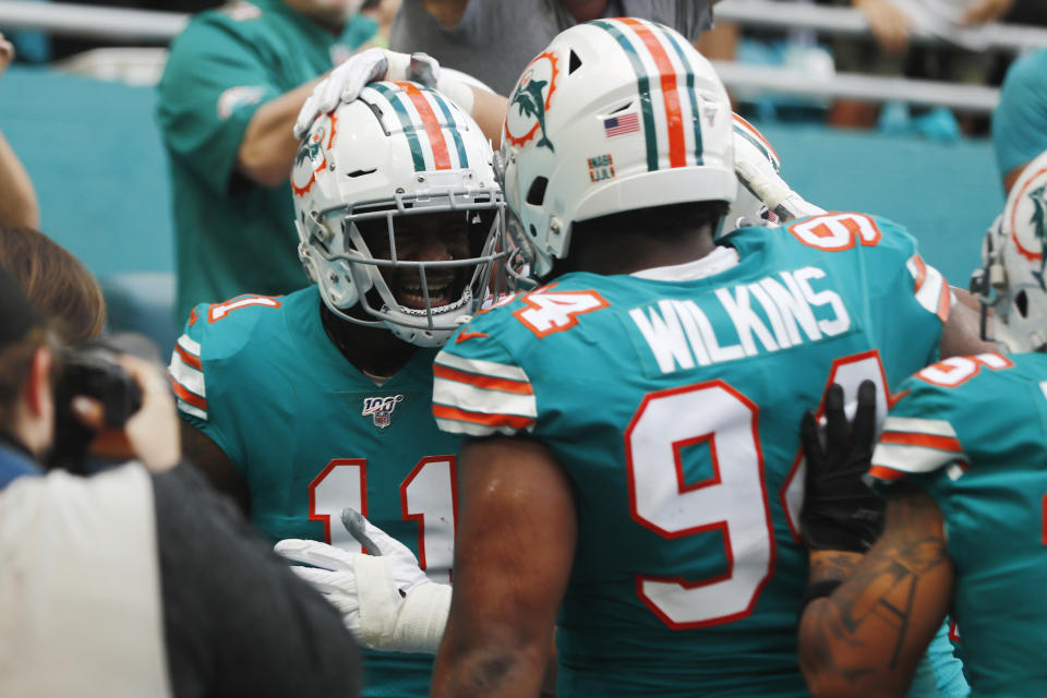 Miami Dolphins defensive tackle Christian Wilkins (94) congratulates wide receiver DeVante Parker (11), after Parker scored a touchdown, during the first half at an NFL football game against the Philadelphia Eagles, Sunday, Dec. 1, 2019, in Miami Gardens, Fla. (AP Photo/Brynn Anderson)