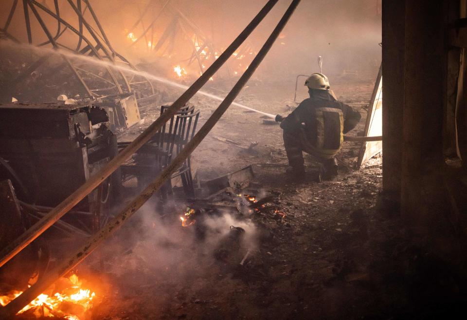 A firefighter fights a fire after Russian attacks struck a warehouse in the suburbs of Kyiv on March 24, 2022. (Photo by FADEL SENNA / AFP) (Photo by FADEL SENNA/AFP via Getty Images)