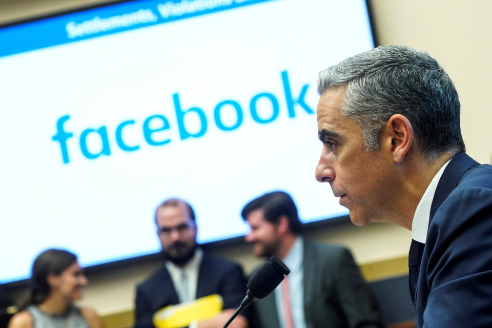 David Marcus, CEO of Facebook’s Calibra, is pictured with a microphone in front of a Facebook background.