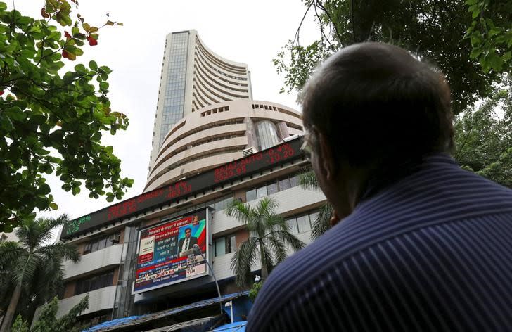 A man looks at a screen across a road displaying the Sensex on the facade of the Bombay Stock Exchange (BSE) building in Mumbai, India, June 29, 2015. REUTERS/Danish Siddiqui/File Photo