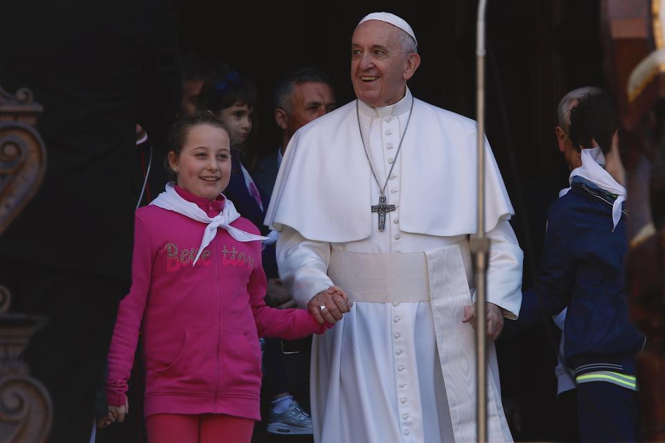 Pope Francis, hands in hand with two children, leaves the Basilica of Our Lady of Loreto where, during a one-day visit, he celebrated mass and prayed in the shrine containing a small house traditionally venerated as the house of Mary, and believed miraculously transplanted from the Holy Land inside the Basilica, in central Italy, Monday, March 25, 2019. The pope chose Loreto to sign the Post-Synodal Exhortation of last October's Synod of Bishops. (AP Photo/Domenico Stinellis)