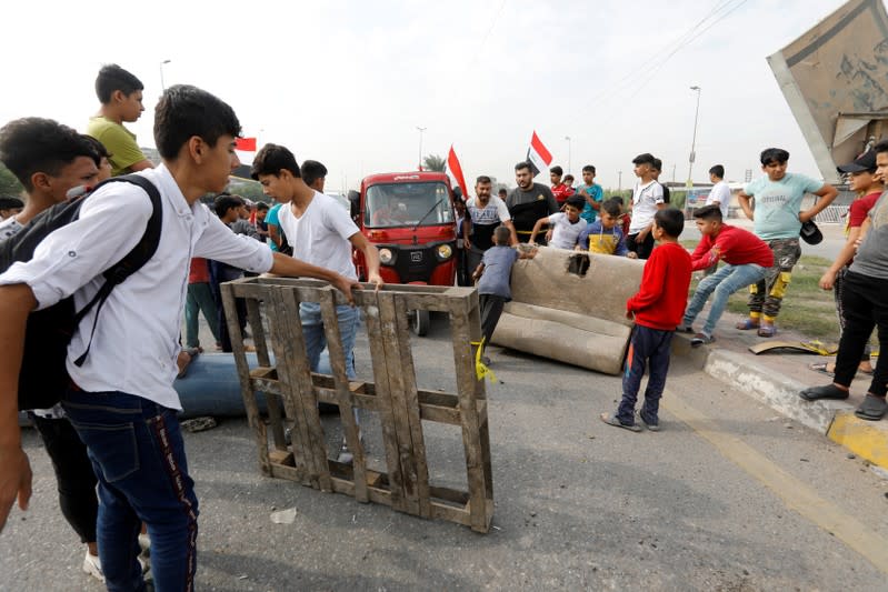 Iraqi demonstrators block the road during ongoing anti-government protests, in Baghdad