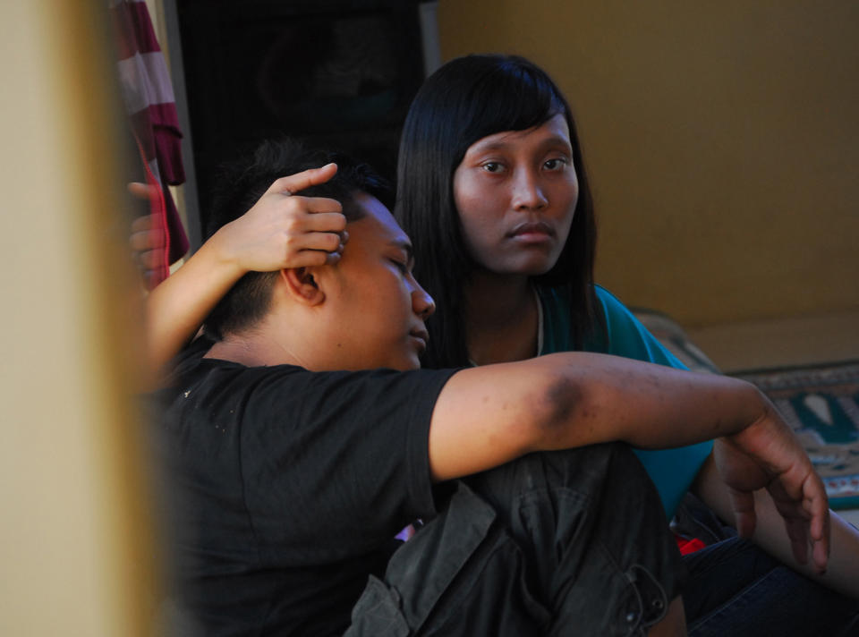 Survivors of the ferry accident on Sunda straits comfort each other at a temporary shelter in Cilegon, Banten province, Indonesia, Wednesday, Sept. 26, 2012. A passenger ferry collided with a cargo ship and sank west of Indonesia's main island Wednesday morning, and at least eight people were killed, officials said. (AP Photo)