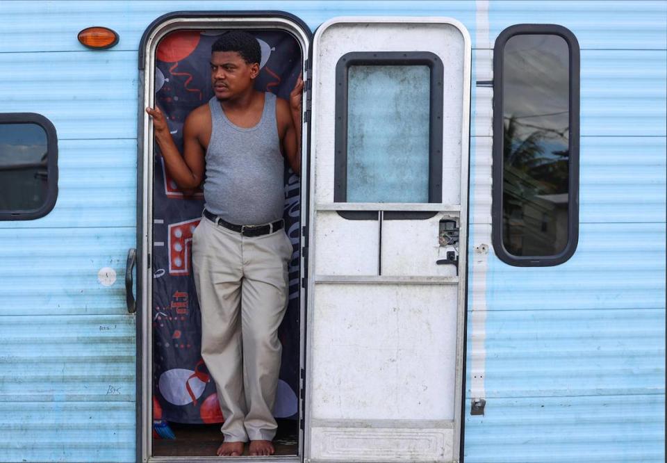 Diamenfull Destin, 42, a father of three, checks on his children while they play outside his trailer. Destin is raising his children alone while his wife remains in Haiti.