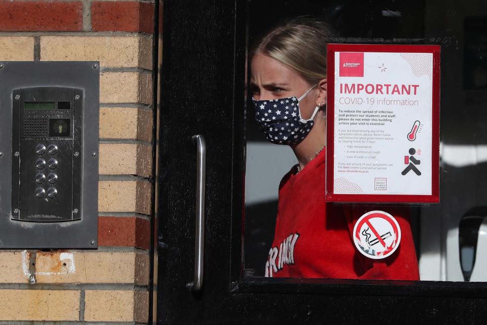 A student leaves one of the accommodation blocks at Murano Street Student Village in Glasgow (PA)