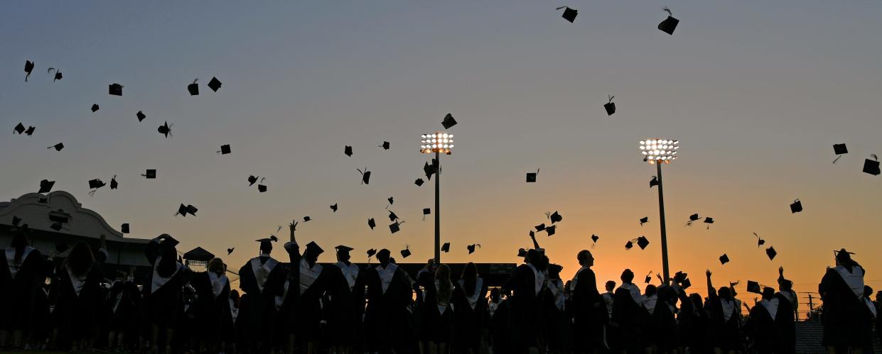 Parrish Community High School graduates toss their caps in the air at the conclusion of their commencement ceremony at LECOM Park. 