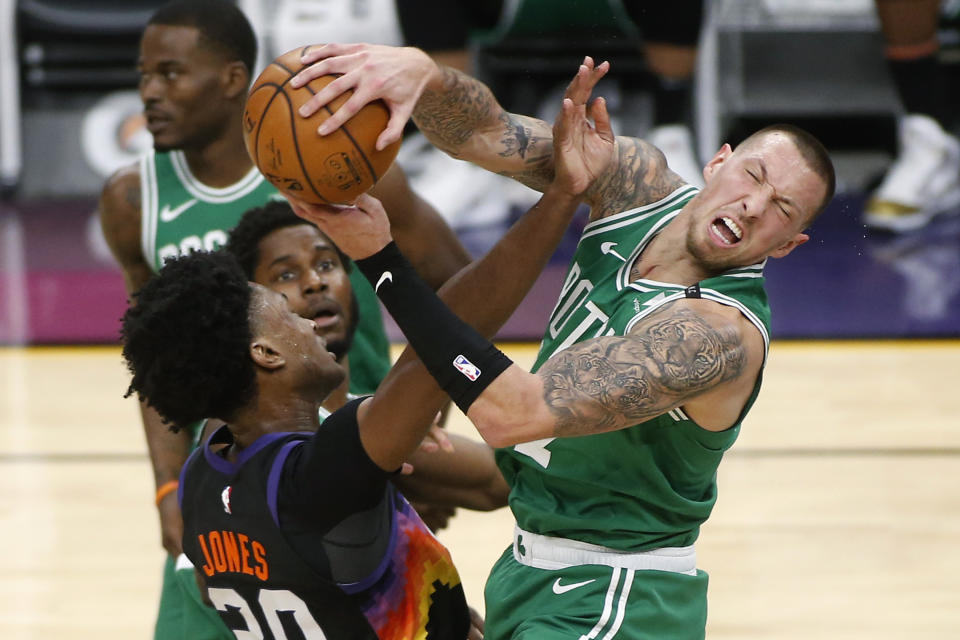 Boston Celtics forward Daniel Theis, right, is fouled by Phoenix Suns center Damian Jones, left, as he grabs a rebound during the first half of an NBA basketball game, Sunday, Feb. 7, 2021, in Phoenix. (AP Photo/Ralph Freso)