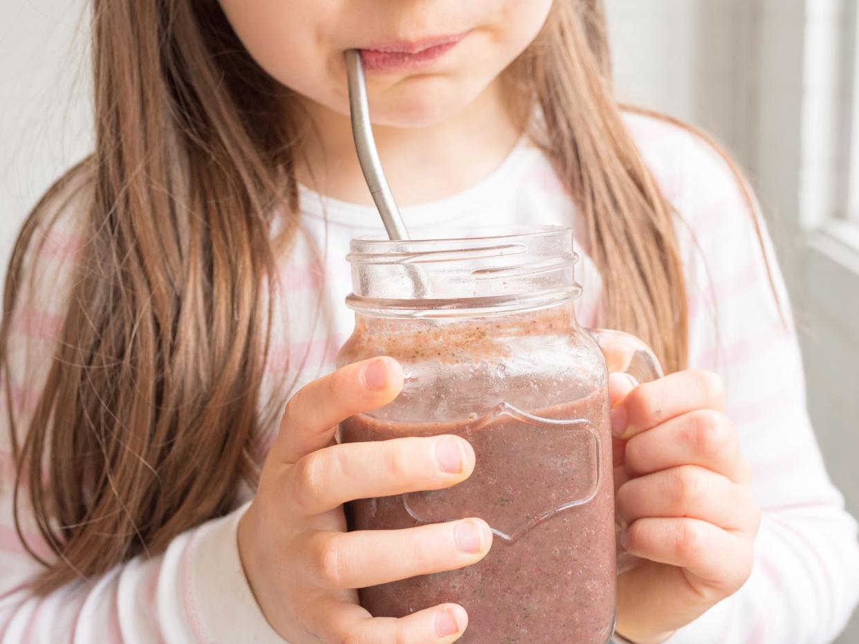 girl drinking smoothie with metal straw