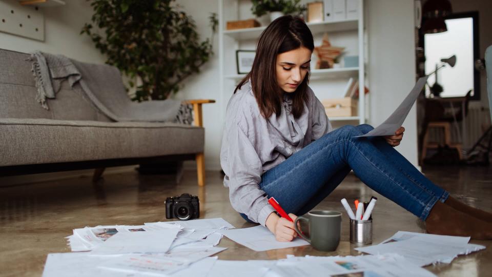 Young woman working on a project on the floor of her future office.