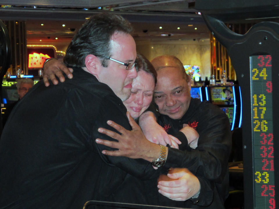 Dealers at the Atlantic Club Casino Hotel hug each other in the seconds after the casino shut down, early Monday, Jan. 13, 2014, in Atlantic City, N.J. The casino was sold at a bankruptcy auction in December to two competitors who will divide its assets but have no desire to operate it. (AP Photo/Wayne Parry)