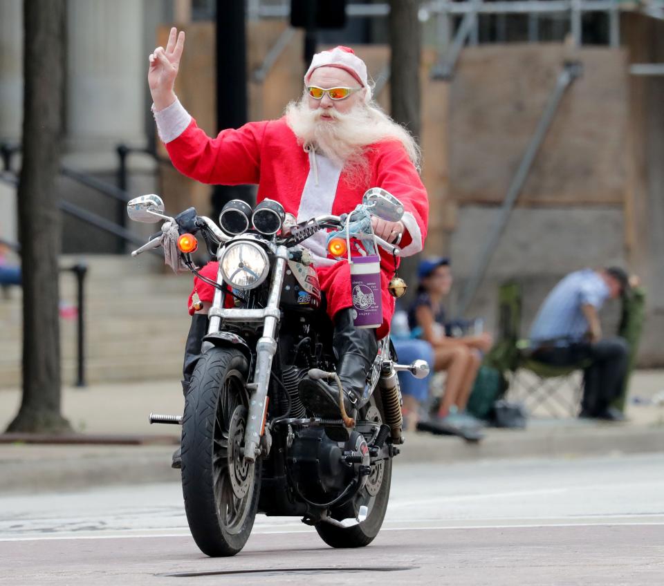 A man dressed as Santa waves to parade-goers during the Harley-Davidson 115th anniversary parade in 2018.