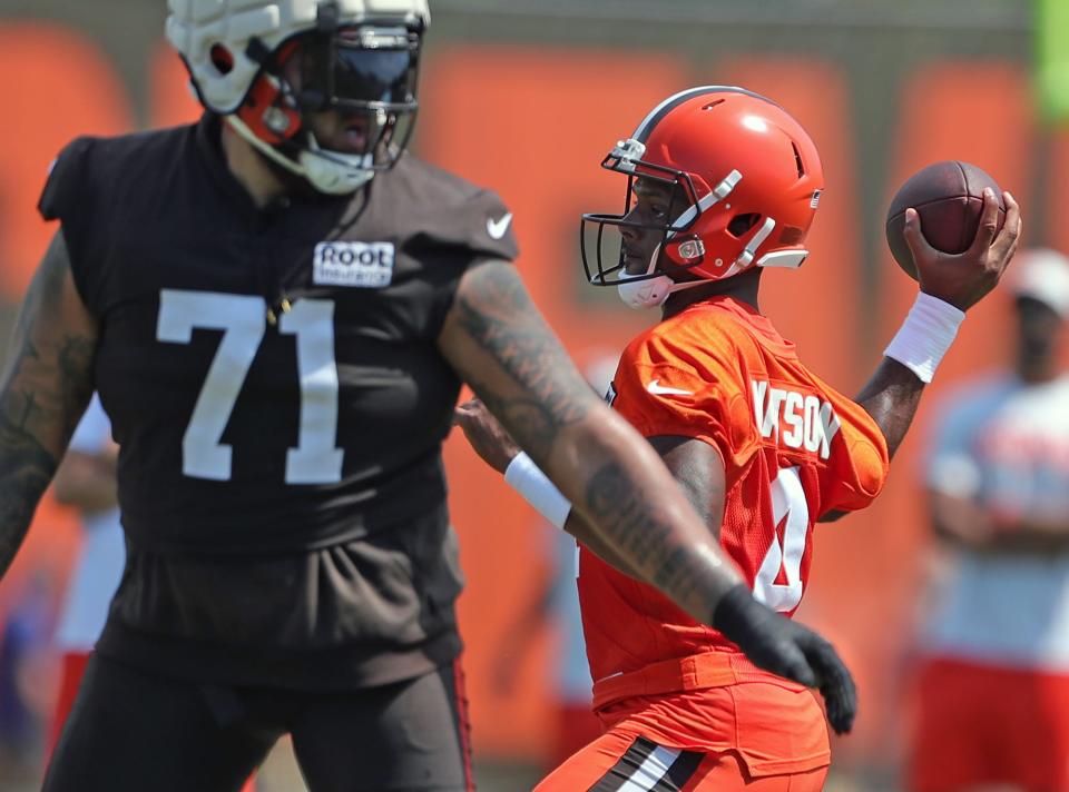 Cleveland Browns quarterback Deshaun Watson, right throws a pass during the NFL football team's football training camp in Berea on Wednesday.