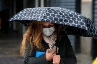 A woman walks in the rain with an umbrella in the Manhattan borough of New York City