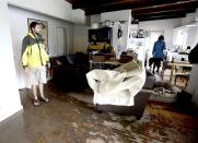 Levin Sliker (L) and Elizabeth Aisenbrey (R) look over the water damage in their home after heavy rains caused flooding in Boulder, Colorado September 13, 2013. (REUTERS/Mark Leffingwell)
